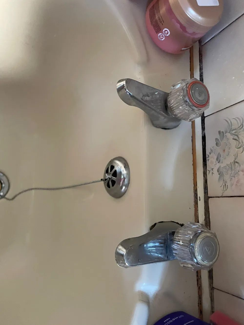 Worn bath taps removed from the wall during a tap replacement