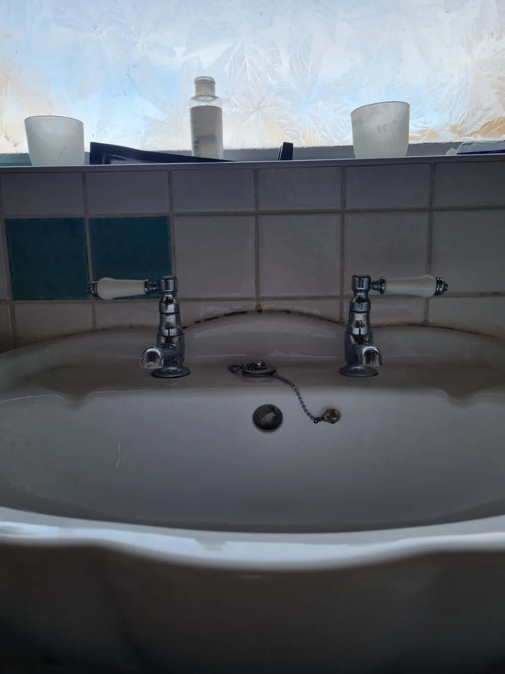 Old worn, leaking chrome basin taps before replacement in Coventry