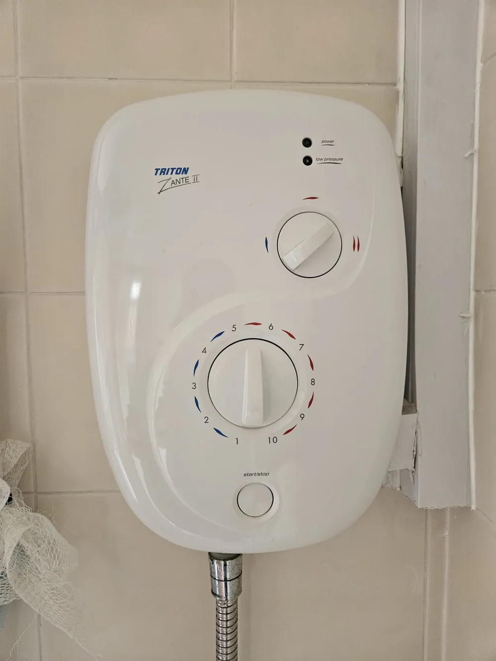 New Triton electric shower unit fitted on a tiled bathroom wall