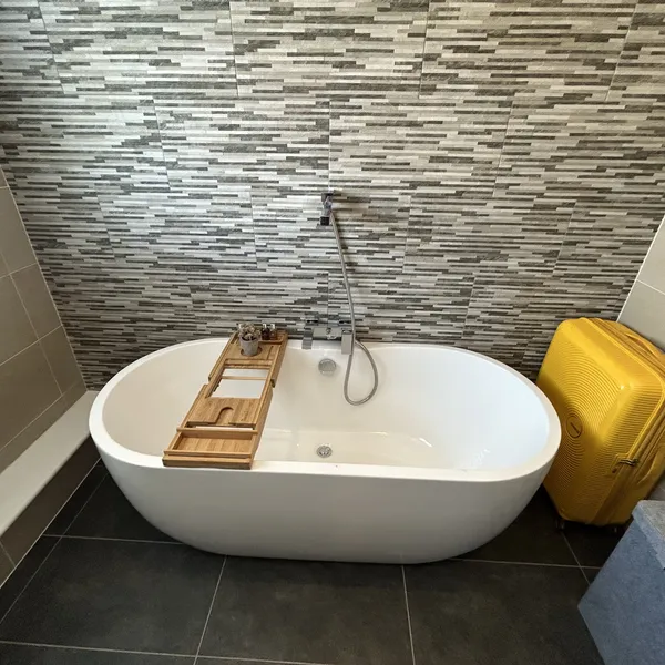 Freestanding bath against a stone feature wall in a Coventry bathroom