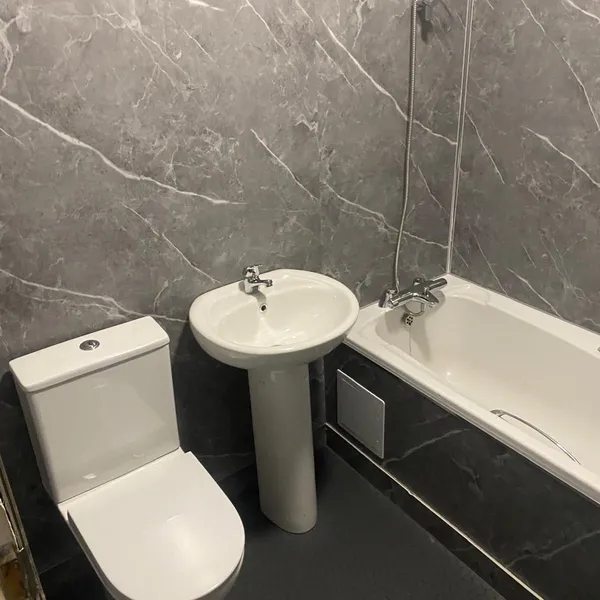 White bathroom suite with dark floor tiles fitted in Coventry